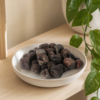 Garnet Tumbled Stone 'B' (India) - 1lb bag in a stoneware dish on a shop shelf