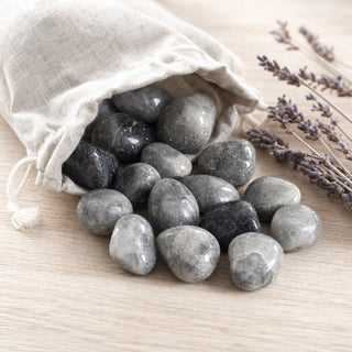 Gray Quartz Tumbled Stones spilling from a linen pouch