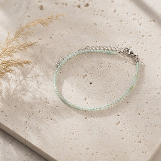 Green Aventurine bead bracelet resting on a stone slab