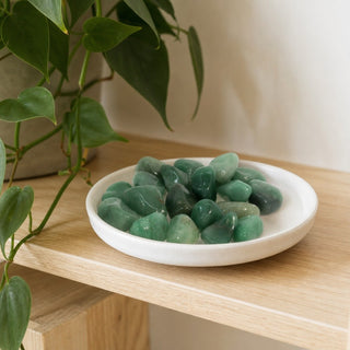 Green Aventurine Tumbled Stones - Brazil in a stoneware dish on a shop shelf