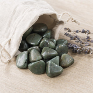 Green Chalcedony Tumbled Stones spilling from a linen pouch