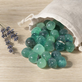 Green Fluorite A Tumbled Stones spilling from a linen pouch