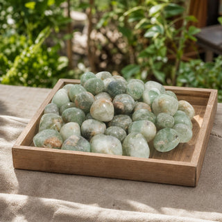 Green Fluorite Tumbled Stones - India in a wooden tray at a market stall