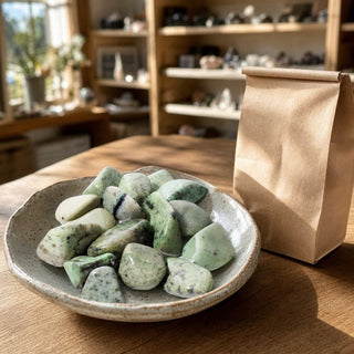 Grossularite Tumbled Stones in a ceramic bowl on a shop counter