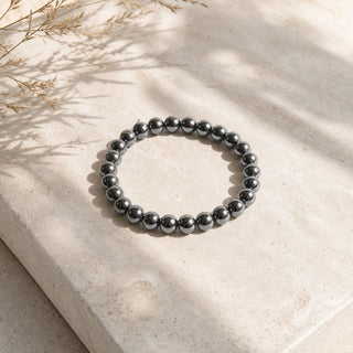 Hematite bead bracelet resting on a stone slab