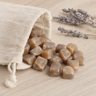 Honey Calcite Tumbled Stones - India spilling from a linen pouch