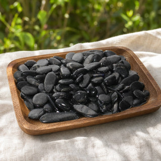 Hypersthene Tumbled Stones in a wooden tray at a market stall