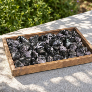 Indigo Gabbro Tumbled Stone in a wooden tray at a market stall