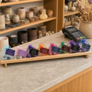 Intention Crystal Collection kits lined up on a wooden riser beside the till in a gift boutique