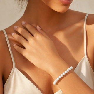 Jade bead bracelet worn with the hand resting on the chest