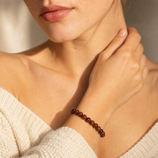 Brecciated Jasper bead bracelet worn with the fingertips resting at the collarbone