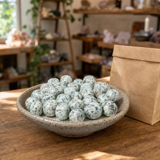 Kiwi Jasper Tumbled Stone in a ceramic bowl on a shop counter