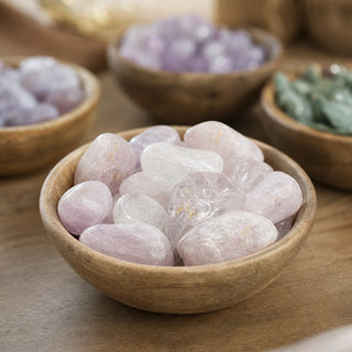 Kunzite Tumbled Stones in a wooden bowl on a boutique display table