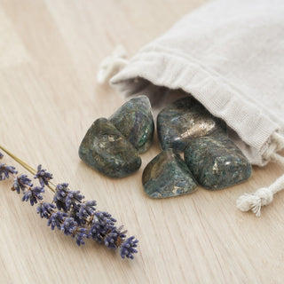 Kyanite Green Tumbled Stones spilling from a linen pouch