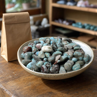 Larimar Tumbled Stones in a ceramic bowl on a shop counter