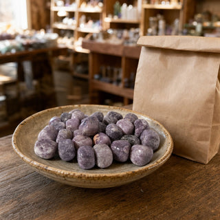 Lepidolite Tumbled Stone 'B' (India) - 1lb bag in a ceramic bowl on a shop counter