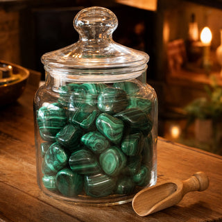 Malachite A Tumbled Stones in a glass apothecary jar with a scoop
