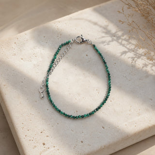 Malachite bead bracelet resting on a stone slab