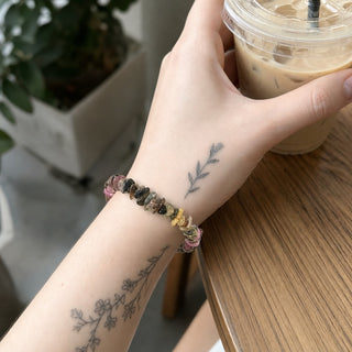 Multi-Colour Tourmaline bead bracelet worn on a tattooed forearm holding a coffee