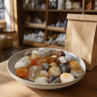 Natural Banded Agate Tumbled Stones in a ceramic bowl on a shop counter