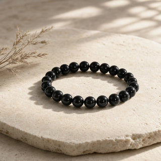 Rainbow Obsidian bead bracelet resting on a stone slab