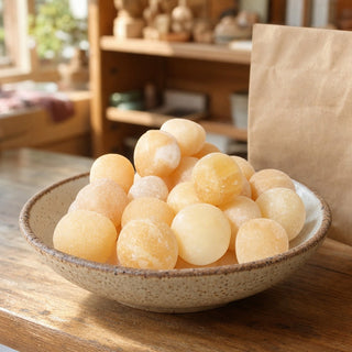 Orange Calcite Tumbled Stones - Mexico in a ceramic bowl on a shop counter