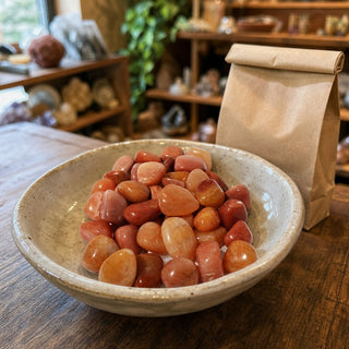 Peach Aventurine Tumbled Stones in a ceramic bowl on a shop counter
