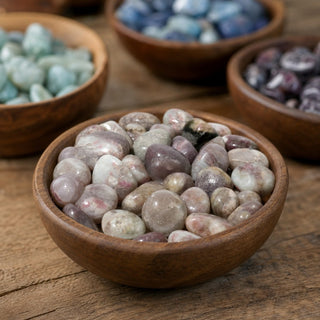 Pink Tourmaline Tumbled Stone in a wooden bowl on a boutique display table
