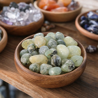 Prehnite Tumbled Stone 'B' (India) - 1lb bag in a wooden bowl on a boutique display table