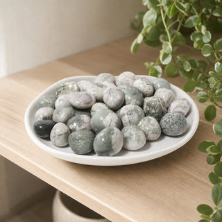 Purple and Green Jade Tumbled Stones in a stoneware dish on a shop shelf