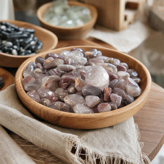 Quartz (Pink Lithium Inclusion) Tumbled Stones in a wooden bowl on a boutique display table
