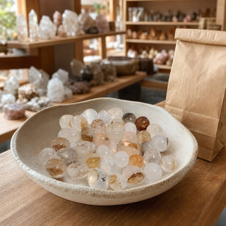 Quartz with Dendrite Tumbled Stones in a ceramic bowl on a shop counter