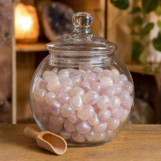 Rainbow Aura Rose Quartz Tumbled Stones (Enhanced) in a glass apothecary jar with a scoop