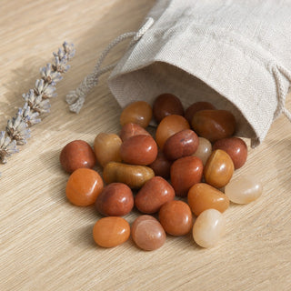 Red Aventurine Tumbled Stones - India spilling from a linen pouch