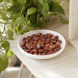 Red Quartz Tumbled Stones in a stoneware dish on a shop shelf