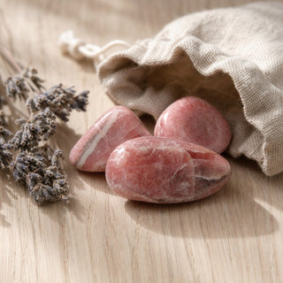 Rhodochrosite E Tumbled Stones #0 - 3 Pack spilling from a linen pouch