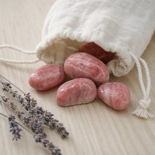 Rhodochrosite E Tumbled Stones #1 spilling from a linen pouch