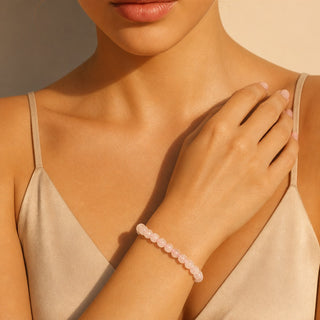 Rose Quartz bead bracelet worn with the hand resting on the chest
