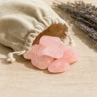 Rose Quartz E Tumbled Stones - Brazil spilling from a linen pouch