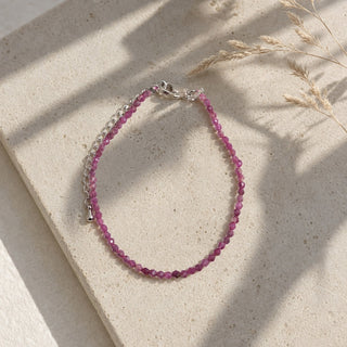 Ruby bead bracelet resting on a stone slab