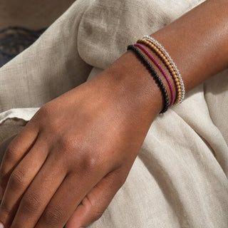Ruby bead bracelet stacked with other bead bracelets on the wrist