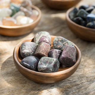 Ruby in Matrix Tumbled Stones in a wooden bowl on a boutique display table