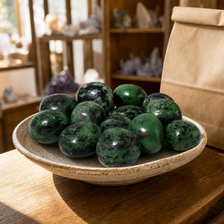 Ruby Zoisite Tumbled Stones in a ceramic bowl on a shop counter