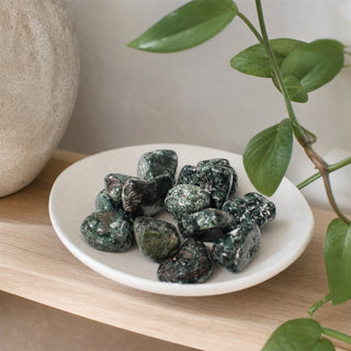 Seraphinite B Tumbled Stones in a stoneware dish on a shop shelf