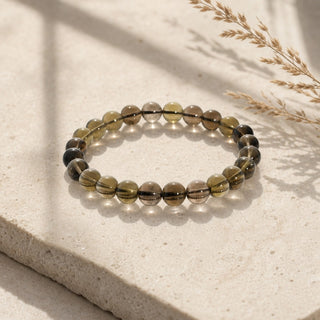 Smoky Quartz bead bracelet resting on a stone slab