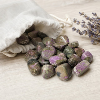 Stichtite Tumbled Stones spilling from a linen pouch