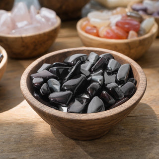 Sugilite in Matrix Tumbled Stones in a wooden bowl on a boutique display table
