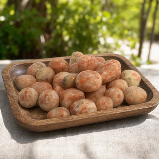 Sunstone A Tumbled Stones - India in a wooden tray at a market stall