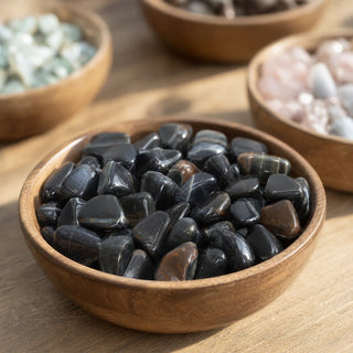 Tiger Eye Blue Tumbled Stones in a wooden bowl on a boutique display table