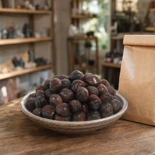 Red Tiger Eye Tumbled Stones - India in a ceramic bowl on a shop counter